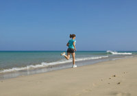 Lauf - Frau in schnellem Lauf am Strand