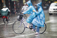 Regenhaut - Zwei Personen auf einem Fahrrad mit Regenhäuten