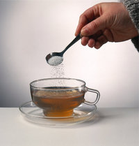 Teelöffel - Teelöffel mit Zucker und eine Tasse Tee Teelöffel - Teelöffel mit Zucker und eine Tasse Tee