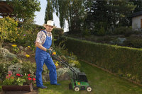 Vertikutiergerät - Mann mit Vertikutiergerät in einem Garten