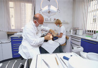 Zahnarztpraxis - Zahnarzt bei der Behandlung eines Patienten in seiner Praxis